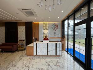 eine Lobby mit einer Person, die an einem Empfangstresen sitzt in der Unterkunft Hotel Three Seasons in Vrindāvan