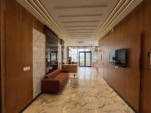 a lobby with a couch and a tv on the wall at Hotel Three Seasons in Vrindāvan