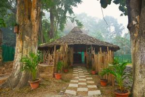 una cabaña de bambú con un camino en un bosque en Gorh Retreat, en Kāziranga