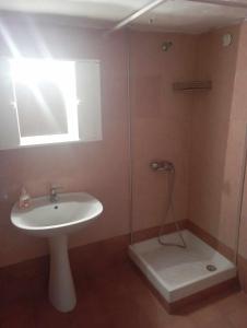a bathroom with a sink and a glass shower at Villa seniorita Annita in Nikiti