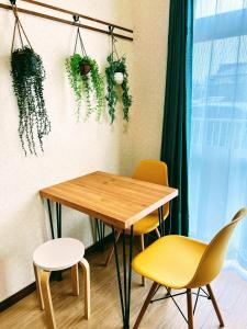 a table and chairs in a room with plants on the wall at メゾンクレスタ in Tokyo