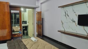 a living room with a tv on a wall at The Inchara Vista in Chikmagalūr