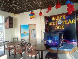 a dining room with two tables and a happy new year sign at Hotel Suite Sadaf in Kelātali