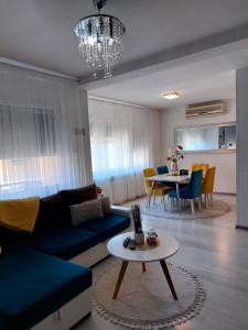 ein Wohnzimmer mit einem blauen Sofa und einem Tisch in der Unterkunft Apartman River Una in Bihać