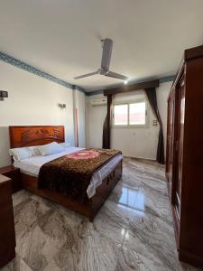 1 dormitorio con 1 cama y ventilador de techo en Valley Of The Kings House en Luxor
