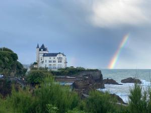un arco iris sobre el océano con una casa y un puente en Ocean Marbella Beach, en Biarritz