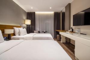 Atakum的住宿－Elite World Comfy Samsun Atakum，酒店客房配有两张床和一张书桌