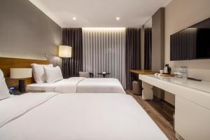a hotel room with two beds and a desk at Elite World Comfy Samsun Atakum in Atakum