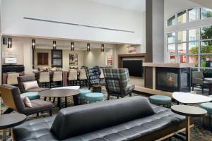 eine Lobby mit einem Kamin sowie Tischen und Stühlen in der Unterkunft Residence Inn by Marriott Fort Myers at I-75 and Gulf Coast Town Center in Estero