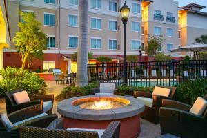 Residence Inn by Marriott Fort Myers at I-75 and Gulf Coast Town Center في استيرو: ساحة مع كراسي ومدفأة امام مبنى
