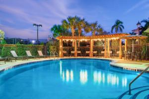 einen Pool mit Stühlen und einem Pavillon in der Unterkunft Residence Inn by Marriott Fort Myers at I-75 and Gulf Coast Town Center in Estero