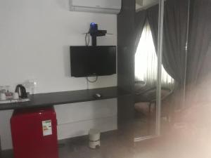 ein Wohnzimmer mit einem TV und einem Fenster in der Unterkunft Loding Lodge in Loding