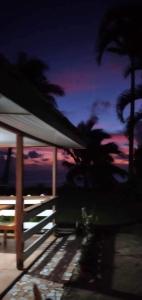 einen Sonnenuntergang mit Palmen und einen Tisch mit einem Zelt in der Unterkunft Maupiti Authentique in Te-Fare-Arii