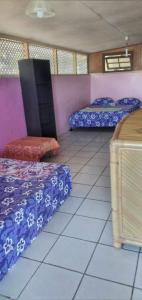 a room with two beds and a chair in it at Maupiti Authentique in Te-Fare-Arii