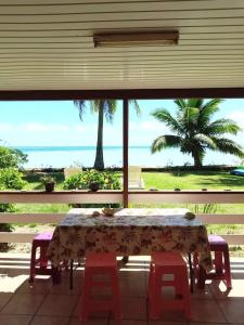a table with two chairs and a view of the ocean at Maupiti Authentique in Te-Fare-Arii