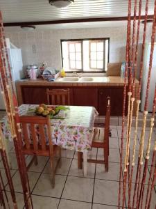 cocina con mesa, sillas y fregadero en Maupiti Authentique en Te-Fare-Arii