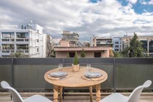 a wooden table on a balcony with a view of a city at Open -view Apartment, YGEIA Hospital in Athens