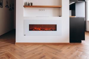a fireplace in a living room with wood floors at Seaside Apartment in Liepāja