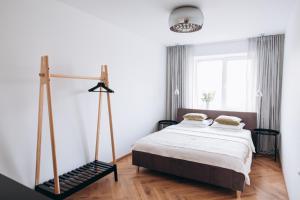 a bedroom with a bed with a wooden floor at Seaside Apartment in Liepāja +17 photos