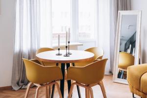 een tafel en stoelen in een kamer met een spiegel bij Seaside Apartment in Liepāja