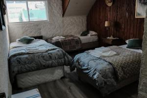 a hotel room with two beds and a window at La Generosa in San Carlos de Bariloche