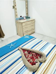 a bedroom with a bed with a blanket and a dresser at Kot Nu - Beach Themed Apartment - 3 mins walk from the sea in Flic-en-Flac