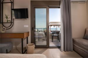 um quarto de hotel com vista para uma sala de estar em Horizon Beachfront Apartments em Laganas