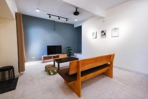 a living room with a couch and a tv on a wall at monstera guesthouse @ Ipoh Garden East in Ipoh