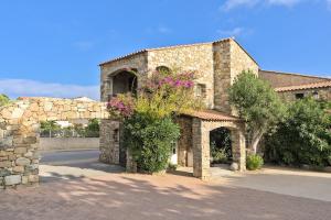 un edificio de piedra con flores a un lado en Hôtel Casa Rossa & Spa en LʼÎle-Rousse