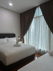 a bedroom with two beds and a large window at Soho Suites KLCC by Angel in Kuala Lumpur