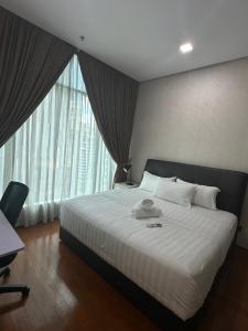 a bedroom with a large bed and a large window at Soho Suites KLCC by Angel in Kuala Lumpur