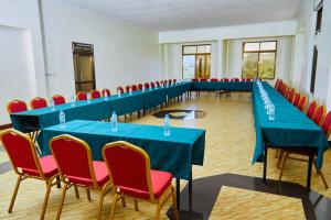 ein Konferenzraum mit blauen Tischen und roten Stühlen in der Unterkunft KILI CRANE LODGE ARUSHA in Arusha