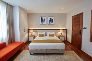 内罗毕Deerpark Luxury Stays的带一张大床和一张红沙发的卧室