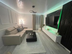 uma sala de estar com um sofá e uma televisão de ecrã plano em Ideal Residence em Lupeni
