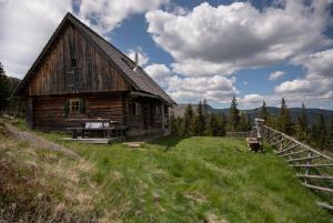 an old barn sitting on a grassy hill at Garanshütte in Schwanberg