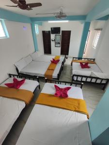 a room with four beds with red bows on them at Sri Aksha Residency in Alāndurai