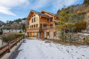 サン・テティエンヌ・ド・ティネにあるChalet Gemme - Magnifique chalet piscine saunaの雪の丸太家