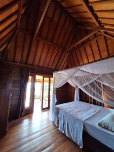 un letto in una stanza con soffitto in legno di Rumah Wayans Lipah ad Amed Altre 67 foto