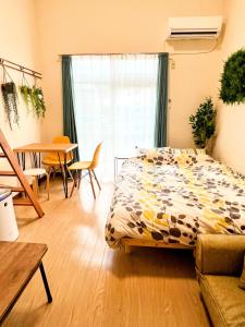 東京的住宿－メゾンクレスタ，卧室配有一张床和一张桌子及椅子