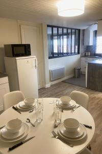 uma mesa branca com placas e talheres em Bel appartement moderne au coeur de Grenoble em Grenoble