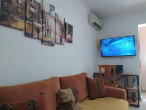 een woonkamer met een bank en een flatscreen-tv bij Mammy's Home in Tirana