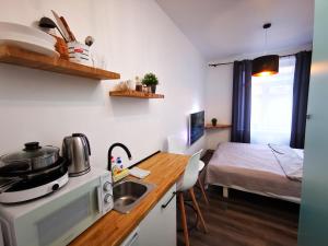 cocina con fregadero y habitación con cama en Urban studio apartment, en Klaipėda