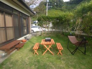 宮崎市にあるGuest House Uminokyojyusya - Vacation STAY 82828vのピクニックテーブルと椅子、グリルのある裏庭