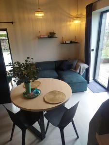 uma sala de estar com uma mesa e um sofá azul em Ateljee Sohie em Hoeilaart