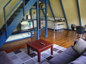 sala de estar con sofá y mesa en The A-Frame, en Halls Gap