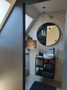 uma casa de banho com um lavatório e um espelho em Ateljee Sohie em Hoeilaart