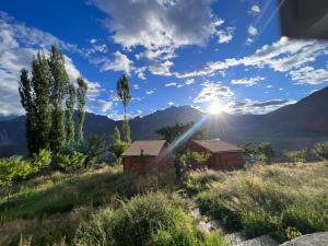 a view of the sun setting over the mountains at Destination Lodges Camp Leo Hoppar Valley in Gilgit