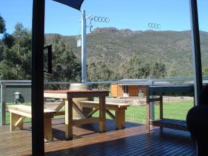 a picnic table on a deck with a view of a mountain at The A-Frame in Halls Gap