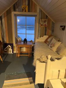ein Zimmer mit einem Bett und einem Tisch und einem Fenster in der Unterkunft Det røde huset på Vågnes in Krokelvdalen