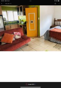 a living room with a couch and a yellow door at Jimmyluh Self Catering in Durban